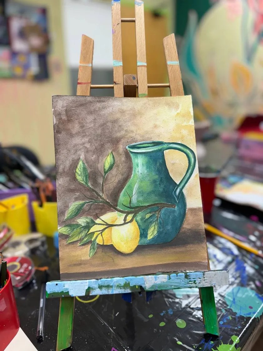 A student still life painting of a jug and lemons on an easel in our Richmond Hill studio