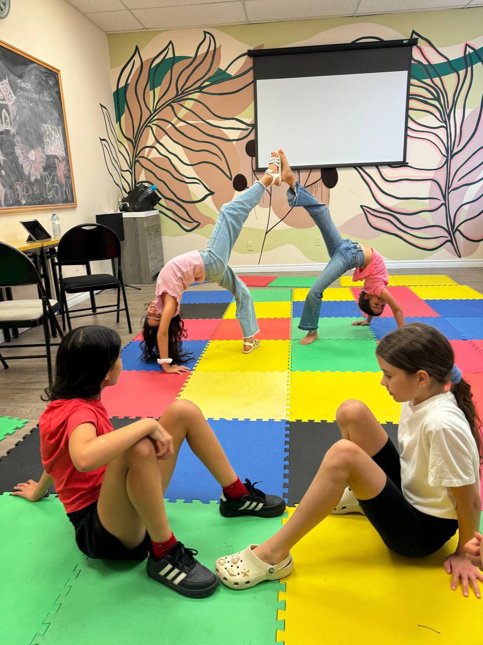 Campers stretching and tumbling on the foam mats between art sessions