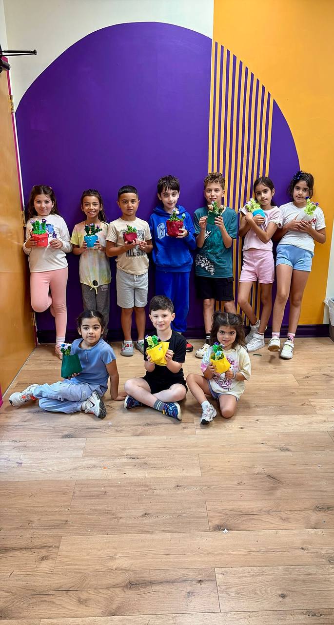 Group of campers holding the decorated plant pots they made at camp