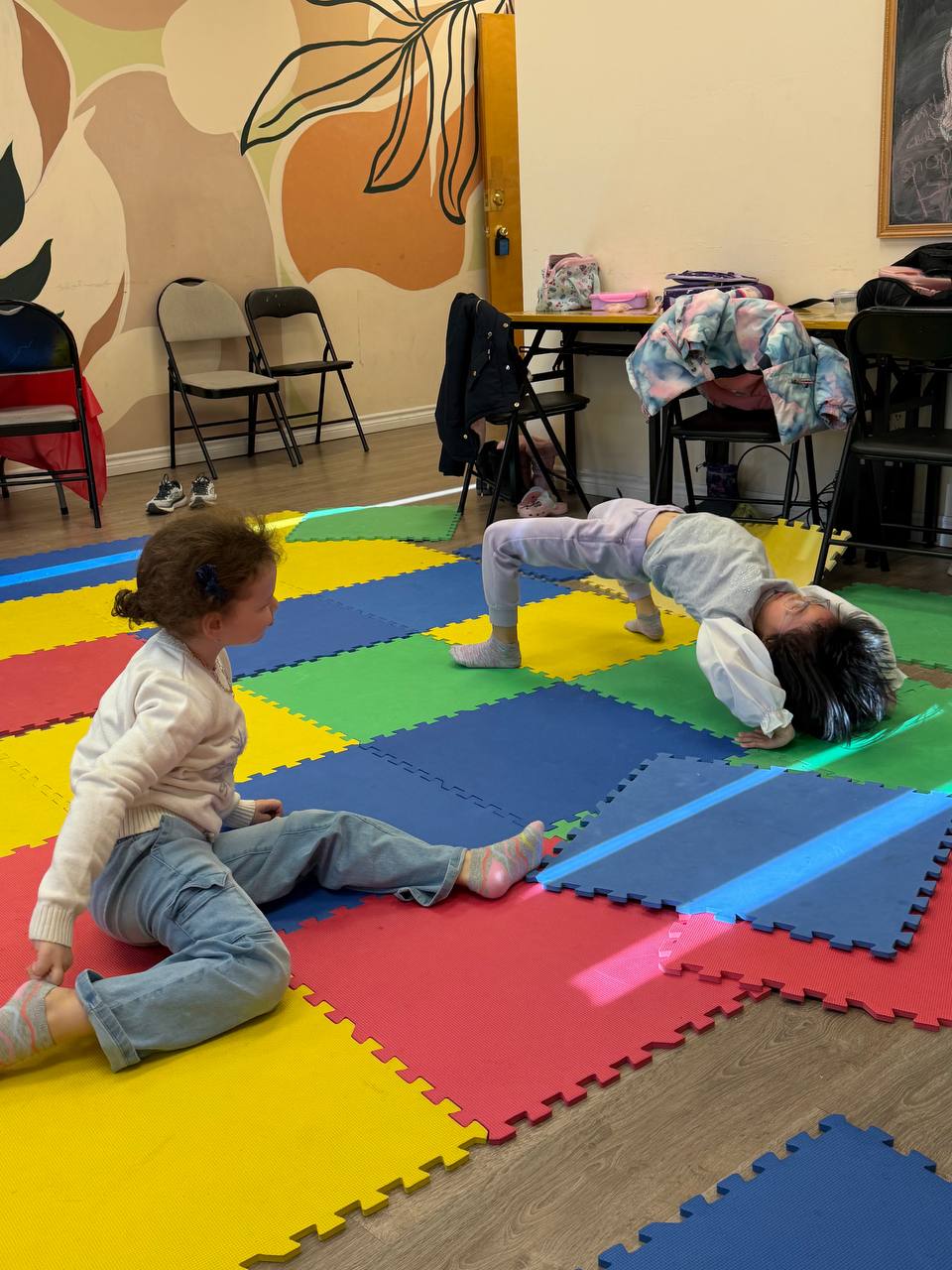 Children playing and stretching on the mats during an activity break